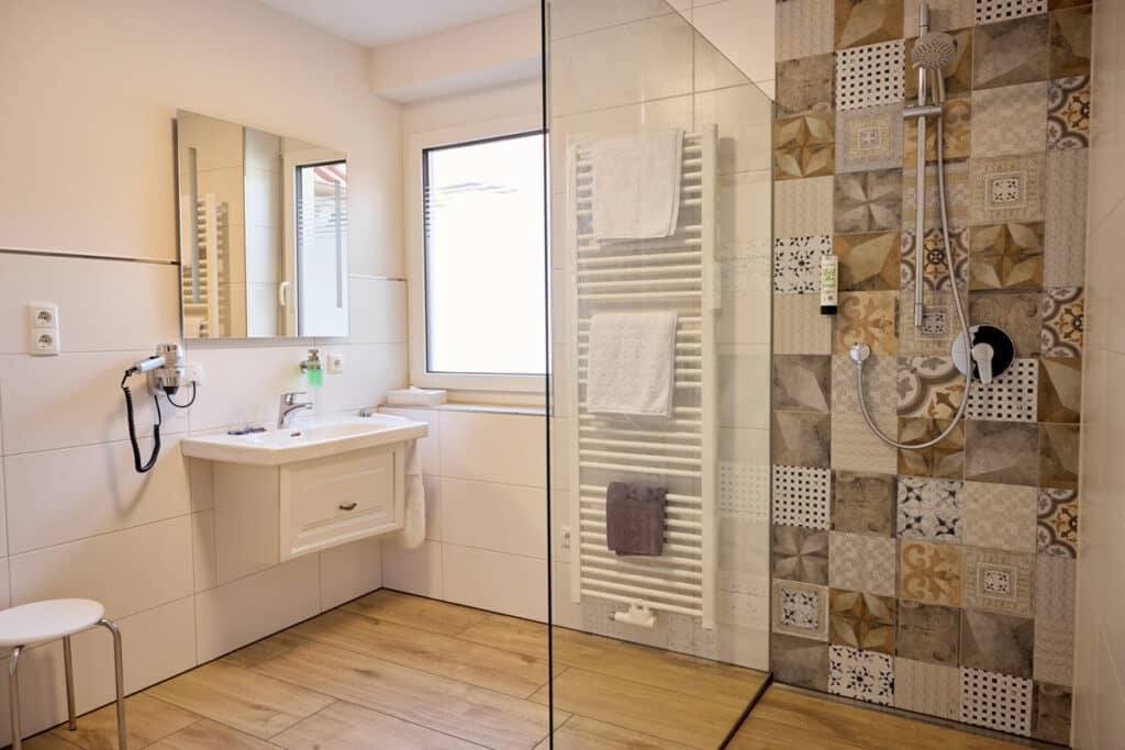 Alle Bäder im neuen Gästehaus Reblitz sind hochwertig ausgestattet und verfügen über eine Walk-in-Dusche, Föhn und kostenfreie Pflegeprodukte.