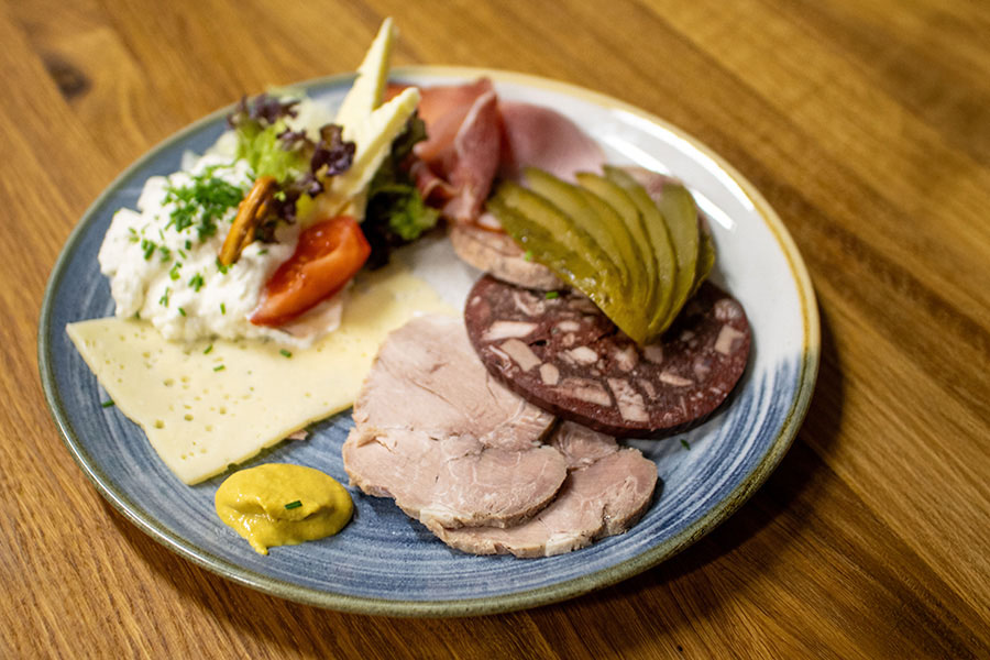 Fränkischer Brotzeitteller mit Wurst, Käse, Essiggurke und Frischkäse im Gasthof Reblitz in Nedensdorf.